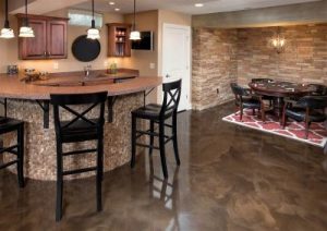Basement space with a bar area, dining table, and brown metallic floor coating