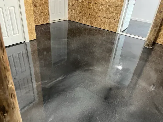 Charcoal metallic epoxy floor coating with a high gloss finish in an unfinished basement