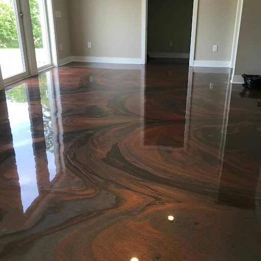 Copper and black swirled metallic epoxy floor in a room with sliding glass doors