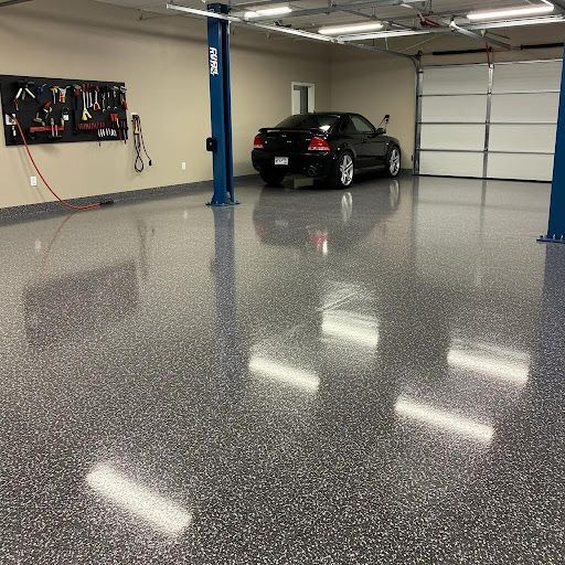 Black car parked in a garage with a two post lift on a full flake epoxy floor