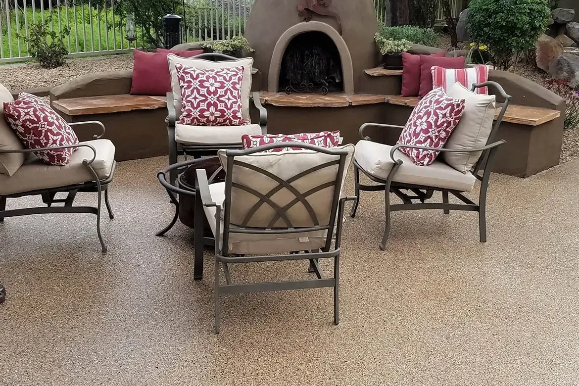 Outdoor patio seating around a stucco fireplace with red and white patterned cushions
