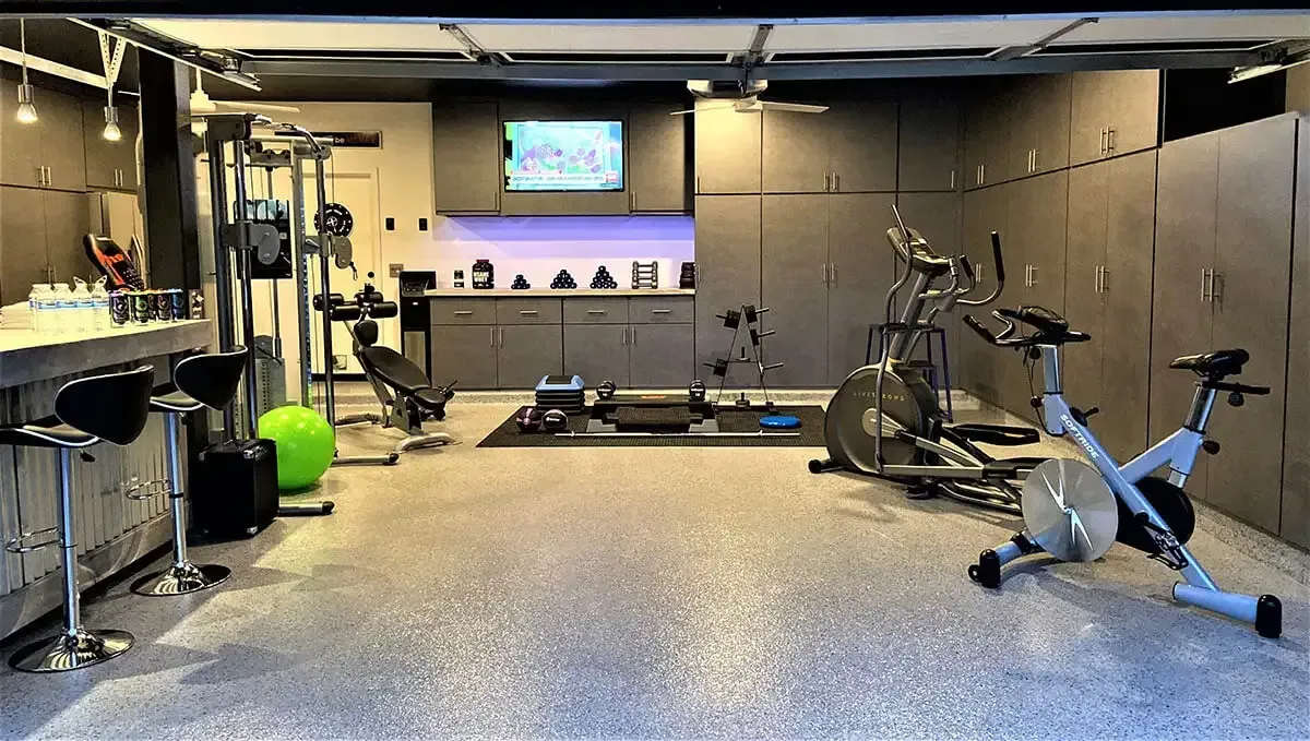 Home gym in a garage with exercise equipment on a full flake epoxy floor