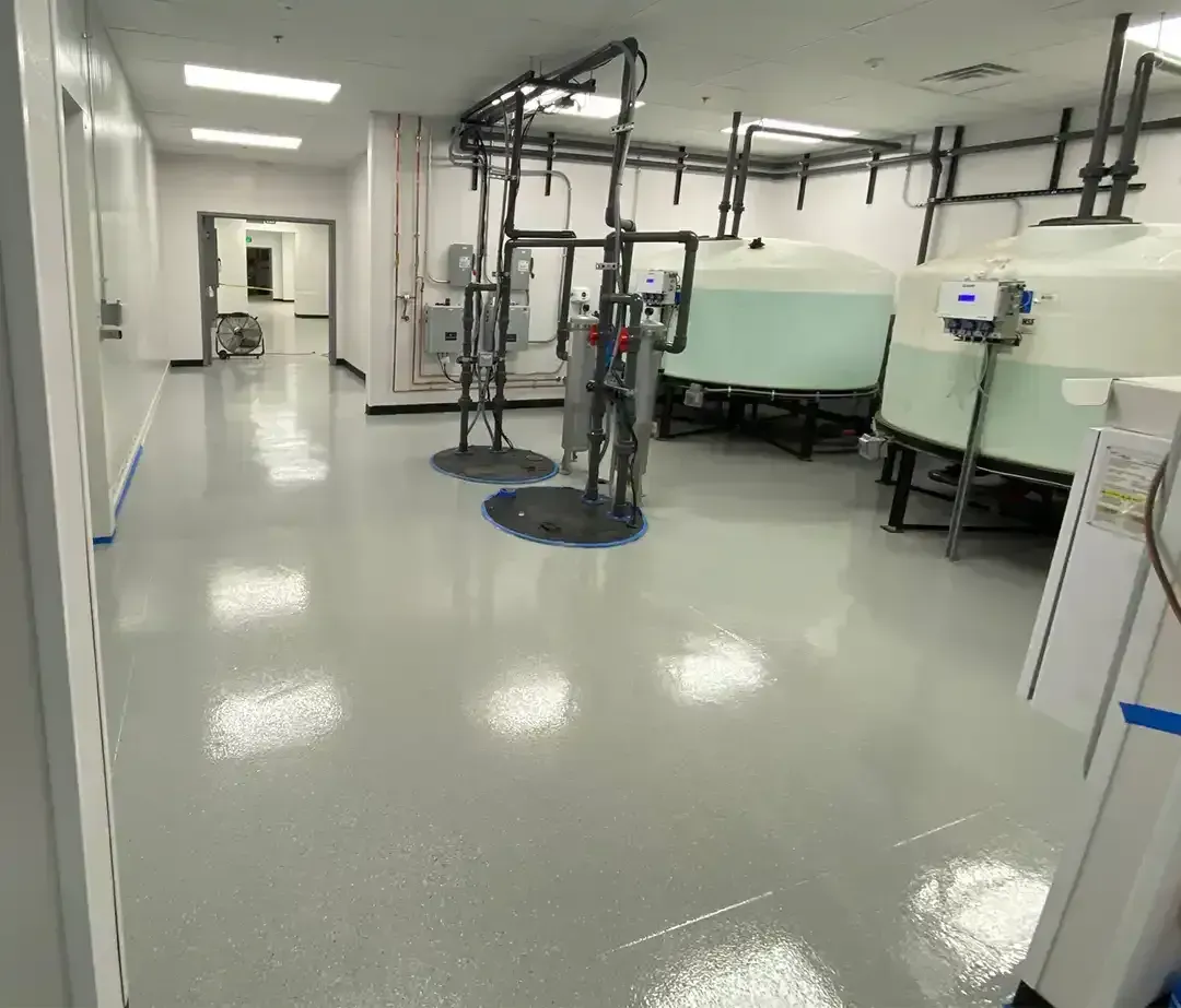 Sterile lab facility with a gray epoxy floor coating, storage tanks and overhead piping