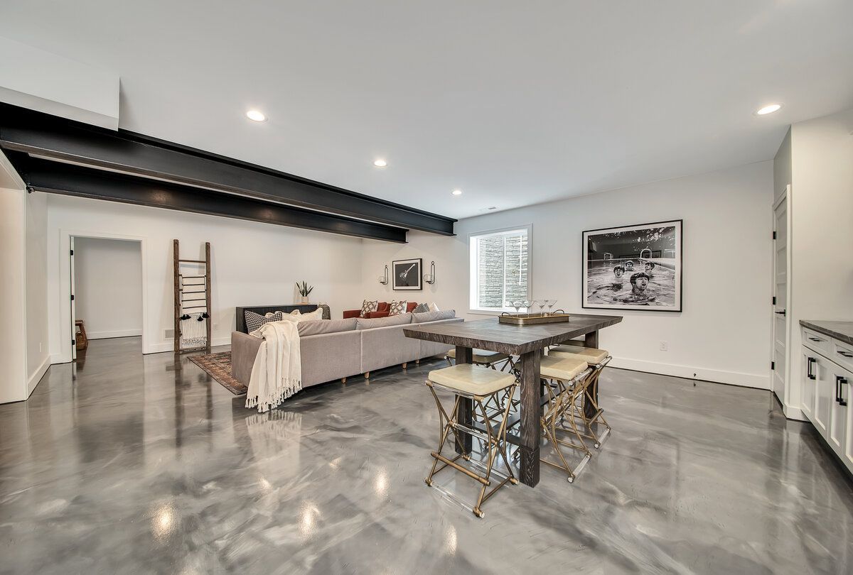 Basement living and dining area with a white and gray marbled metallic epoxy floor