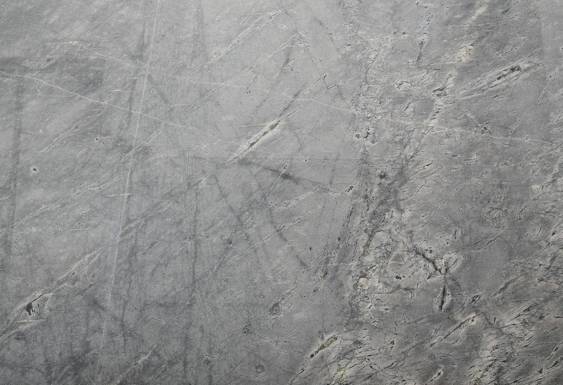Close up of a bare gray concrete floor surface with minor scratches and imperfections