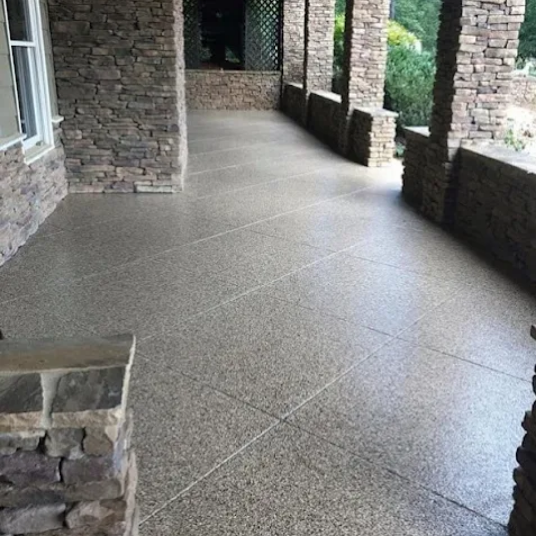 Covered stone column porch with a full flake speckled epoxy floor and lattice trellis