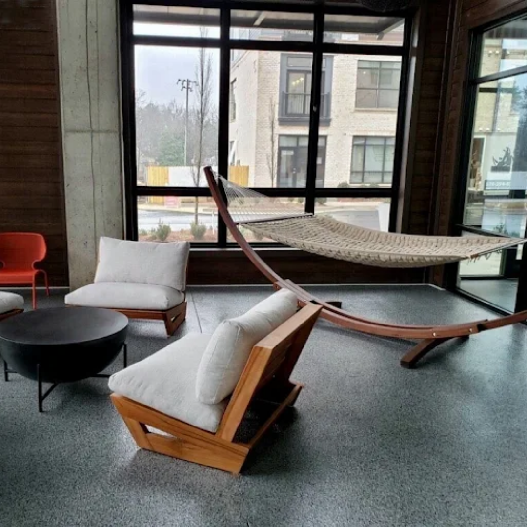 Lounge area with a rope hammock and wood frame chairs on a full flake gray floor