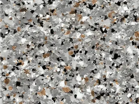 Close-up of a full flake epoxy floor in cream, gray, black, and copper chips