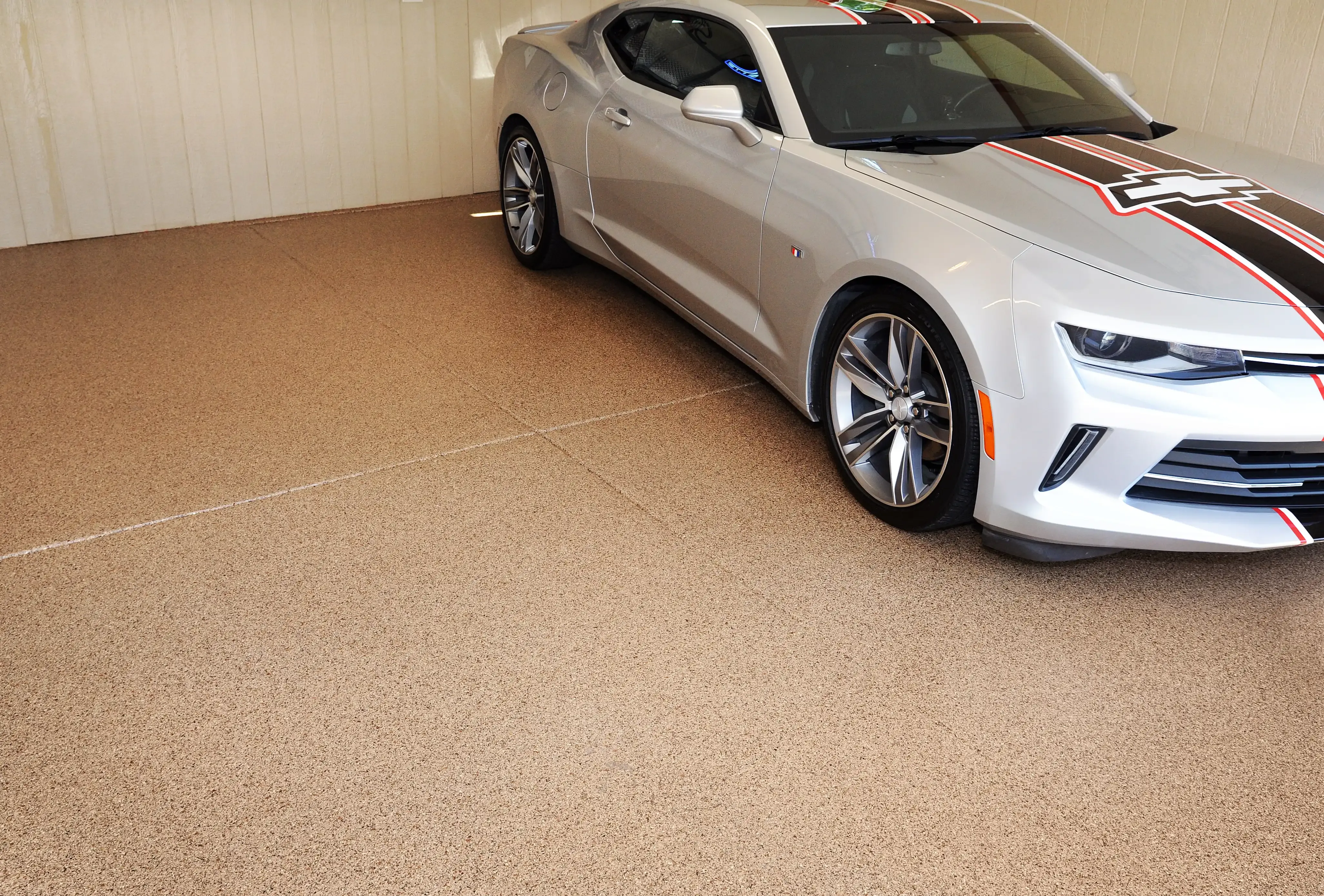 Silver muscle car with a red racing stripe on a tan full flake epoxy garage floor