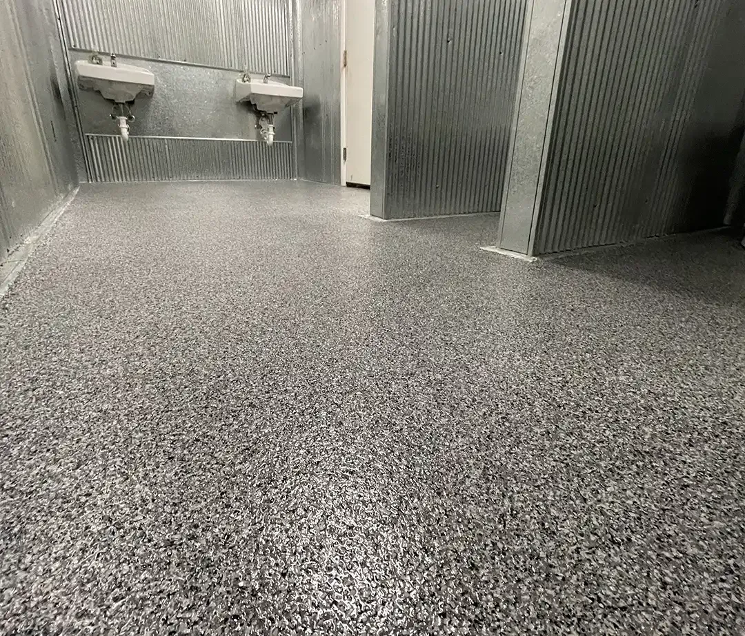 Corrugated metal utility room with two wall mounted sinks on a full flake epoxy floor