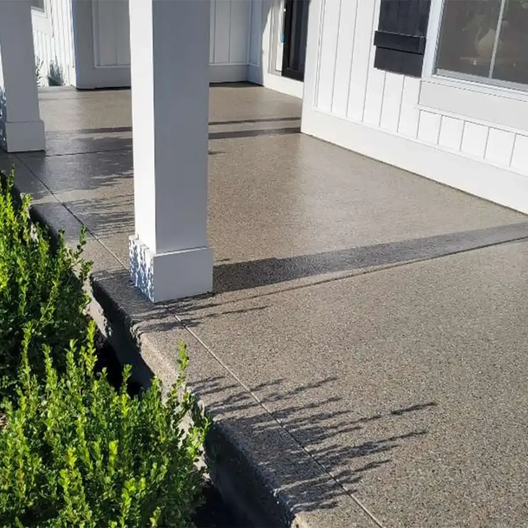 Covered concrete patio with a full flake epoxy floor coating and white porch pillars
