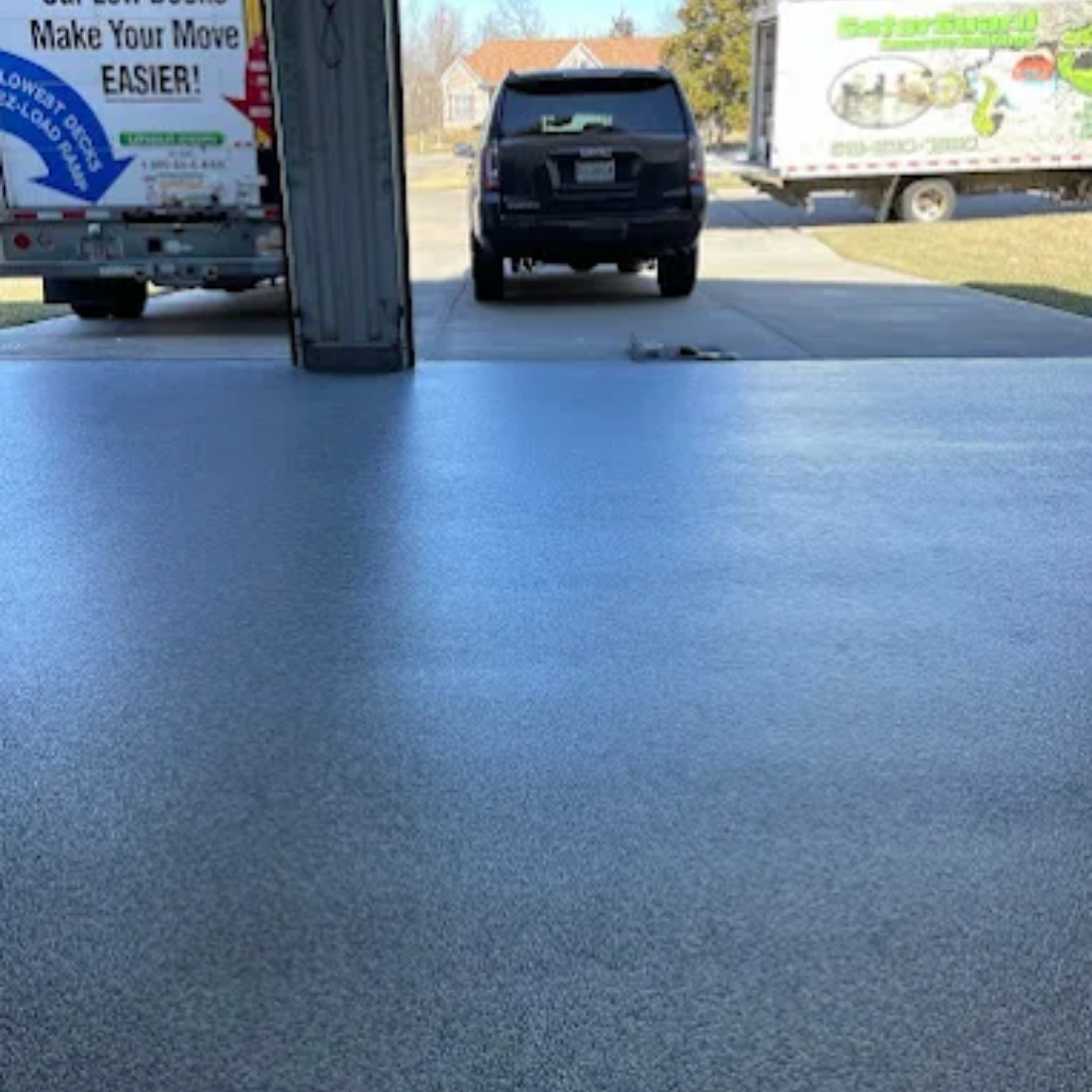 Garage with a full flake blue gray epoxy floor and a GatorGuard truck parked outside