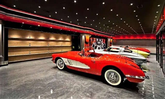 Showroom with metallic epoxy floor, red vintage Corvette, and other classic cars